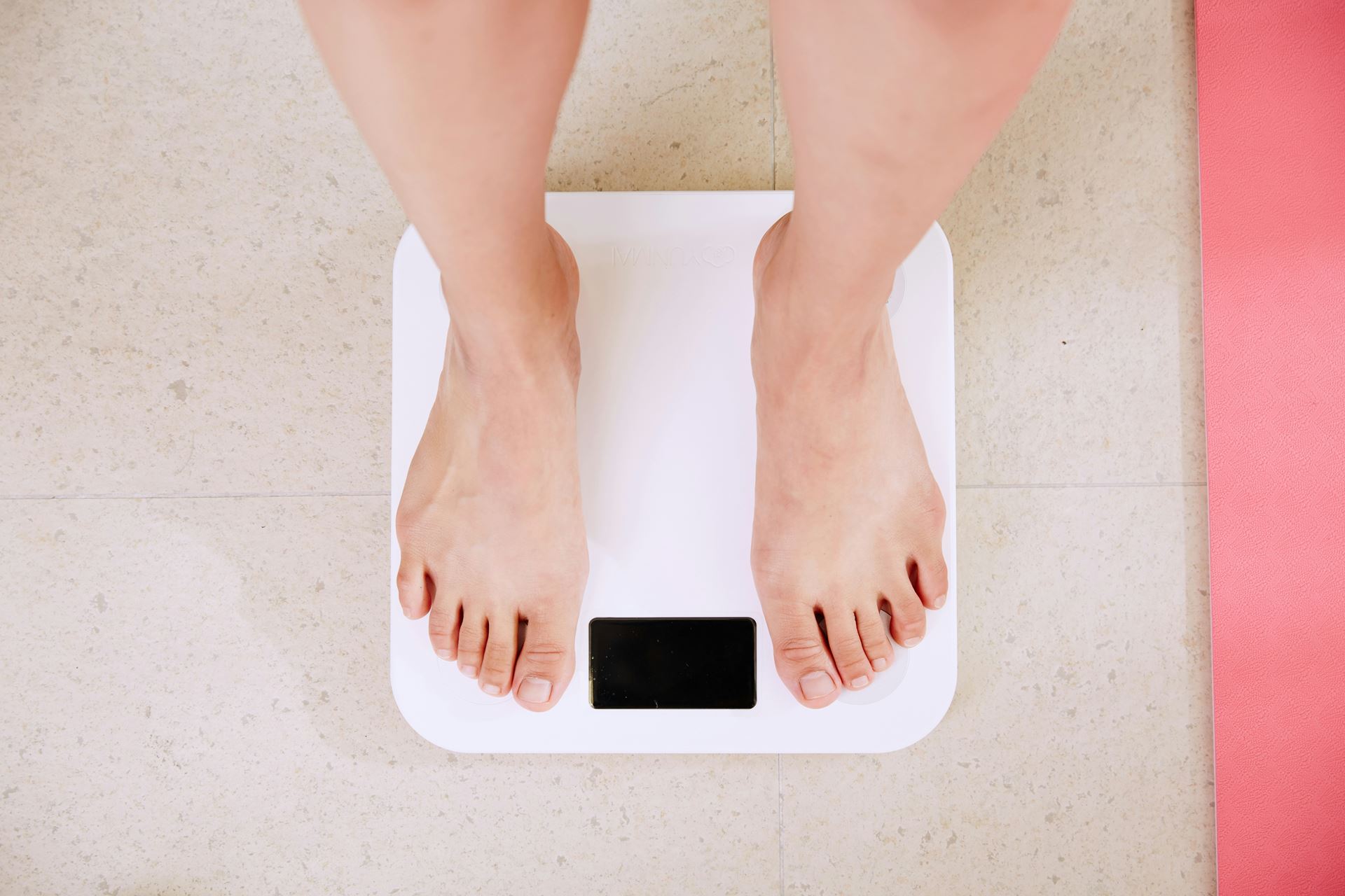 two naked feet stood on weighting scales
